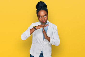 Young african american woman wearing business clothes doing time out gesture with hands, frustrated...