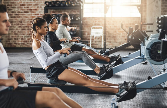 Determination keeps the fitness dream alive. Shot of a group of young people working out with rowing machines in the gym.