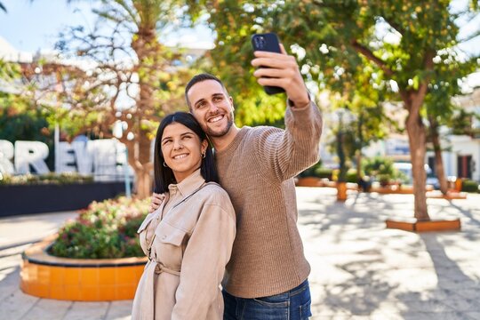 Man and woman couple smiling confident making selfie by the smartphone at park