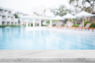 Empty white marble stone table top and blurred swimming pool in tropical resort in summer banner background - can used for display or montage your products. - 493717395