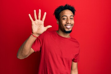Young african american man with beard wearing casual red t shirt showing and pointing up with...