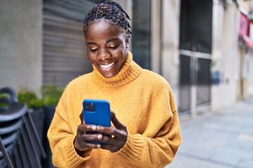 African american woman smiling confident using smartphone at street