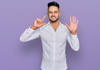 Fototapeta premium Young arab man wearing casual clothes showing and pointing up with fingers number seven while smiling confident and happy.
