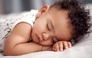 Sleep well little one. Shot of an adorable baby boy sleeping peacefully on the bed at home.