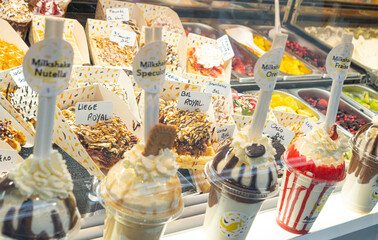Delicious traditional waffles with whipped cream on display in a store window in Brussels, Belgium. Typical Belgian sweet food.
