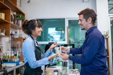 happy barista take order with tablet from customer in coffee shop.