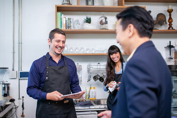 happy barista take order with tablet from customer in coffee shop.