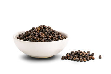 Pile of black pepper seeds and black pepper seeds in white ceramic cup isolated on white background.