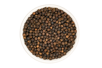 Top view of dried natural black pepper seeds in white ceramic cup on white background.