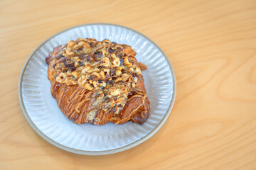 Roasted Hazelnut Coffee Croissant is a delicious homemade bakery on a wooden table. Traditional French breakfasts crispy croissants baked pastries are favorited worldwide.
