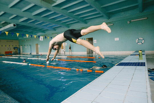 Male swimmer jumping in a swimming pool
