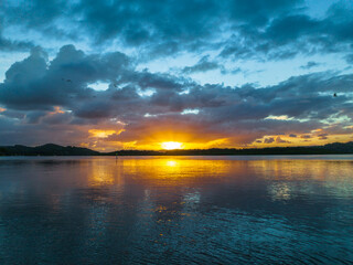 Sunrise, birds and rain clouds waterscape