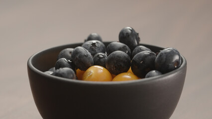 blueberries in black bowl with physalis closeup