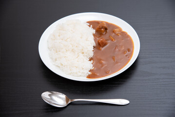 黒背景で丸皿に盛り付けたカレーライス