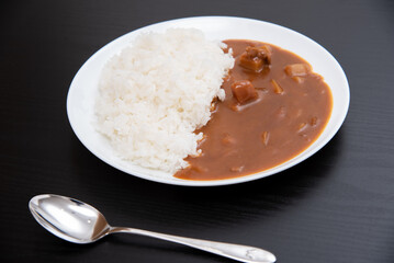 黒背景で丸皿に盛り付けたカレーライス