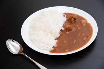 黒背景で丸皿に盛り付けたカレーライス
