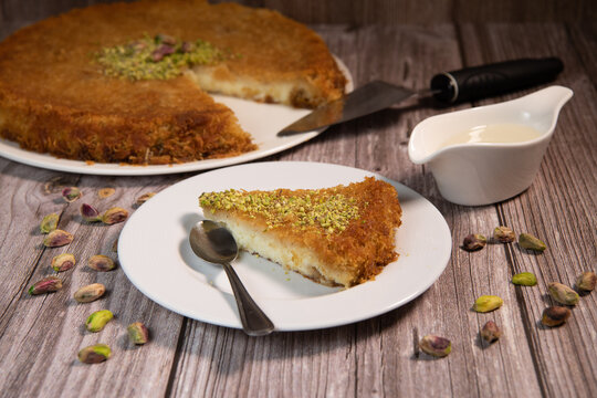 Delicious Traditional Dessert Knafeh with cheese and pistachios and orange flower syrup, High quality photo