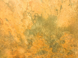 Rusty yellow metal wall with stains and scuffs. Vintage background with texture. Rough surface.

