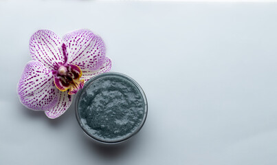 natural body or face scrub. olive and clay body polish, sea ebbles, orchid flower. flat layx top biew. spa, wellness and relax concept . skin care. advertising template 
