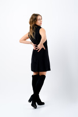 Stylish senior woman in little black dress walking in studio