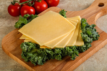 Sliced Gauda cheese over board