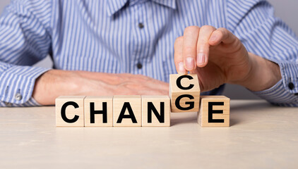 Hand flipping cube with word chance to change. Man sitting at table with wooden cubes. Personal development, career growth, success, positive thinking concept. High quality photo