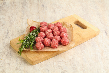 Raw uncooked beef meatballs served rosemary