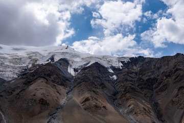 Glacier on rocky mountains. Melting glaciers due to global warming climate change problem. Barskoon mountain pass. Travel tourism in Kyrgyzstan concept.