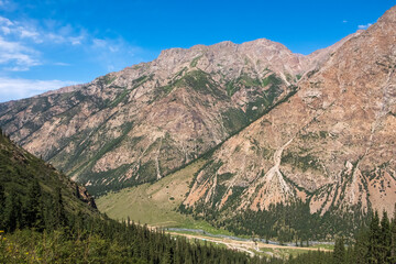 Beautiful mountain valley with rocky mountains and sky. Barskoon river mountain gorge. Travel,...