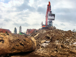 Excavator with lattice shovel stands on a building rubble pile, in front of which an excavated...