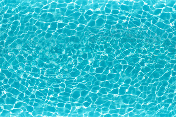 The excitement of the water in the pool. The texture of the surface of the blue pool, the background of the water in the pool with sun glare. copy space.