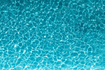 The excitement of the water in the pool. The texture of the surface of the blue pool, the background of the water in the pool with sun glare. copy space.