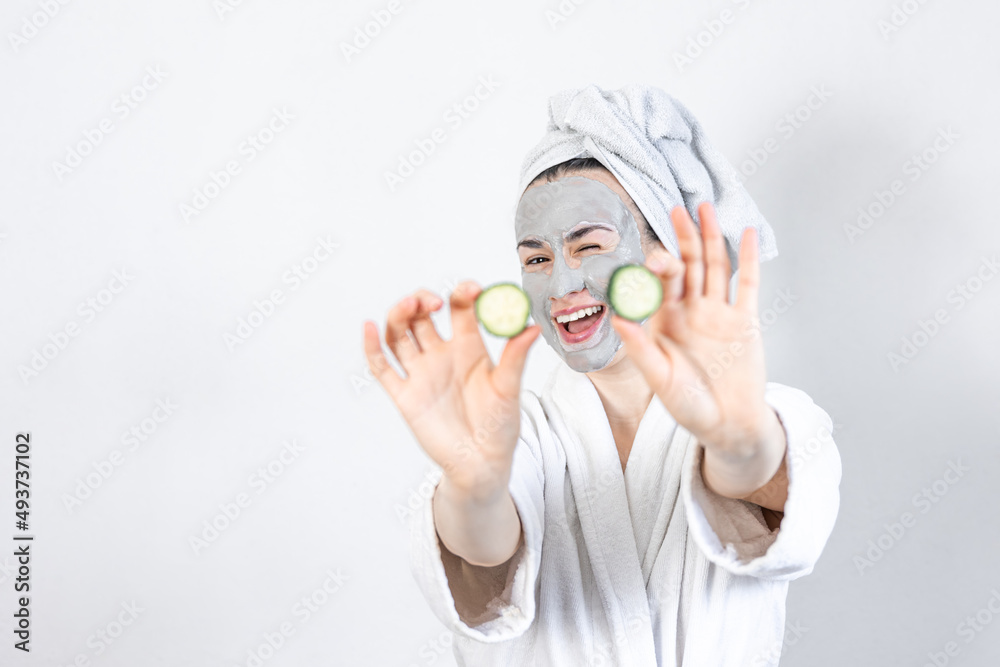 Poster a young woman with a clay mask on her face.