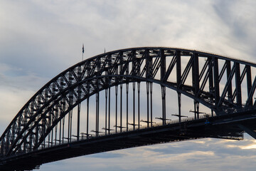 Close-up view of Sydney Harbour Bridge with cloudy sky.
