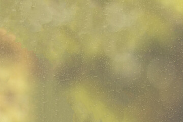 The surface of a window pane stained and streaked by dried raindrops. Blurred texture with smooth transitions.