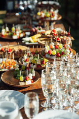 A table of various snacks, sandwiches, strawberries and other types of snacks.