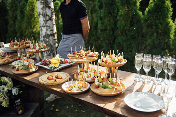 A table of various snacks, sandwiches, strawberries and other types of snacks.