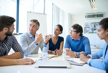 It all started with this great idea.... Shot of a group of businesspeople discussing work during a...