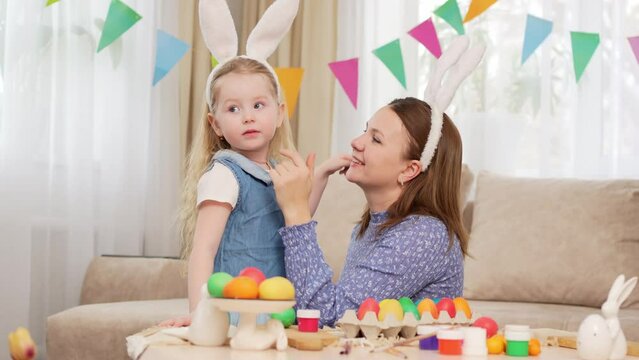 mom and little daughter with rabbit ears celebrate Easter and and have fun 