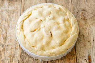 Raw Tart dough, shortcrust pastry with cutted apples, in ceramic tart pan. Baking an apple pie. Step by step recipe