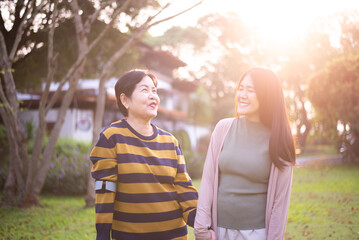 Fototapeta premium Asian mature mother happy with hand daughter take care and support at outdoor,Health insurance and elderly care,Family caregiving concept