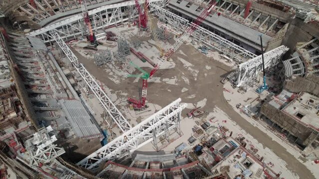 Aerial view of construction site with cranes working on a building area. Construction site of a large stadium.