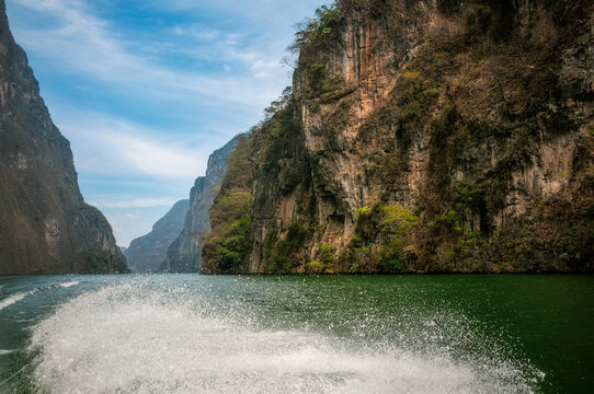 The trail of the tour boat at Sumidero Canyon, a deep natural canyon located on the Grijalva River in Chiapas State in Southern Mexico. The Canyon's vertical walls can reach up to 1,000 meters high.