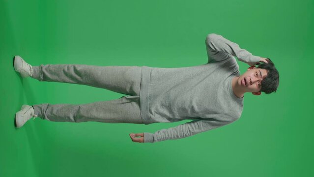 Full Body Of Puzzled Asian Man Is Standing In Front Of Green Screen Background
