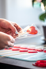 Packaging of red lollipops in the shape of hearts.