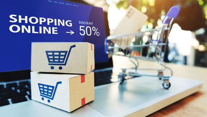 Promotion Shopping online with paper boxes and shopping cart on computer notebook.