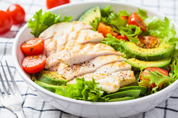Grilled chicken breast salad with avocado and cherry tomatoes. Healthy diet food concept.