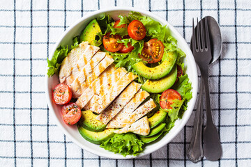 Grilled chicken breast salad with avocado and cherry tomatoes. Healthy diet food concept.