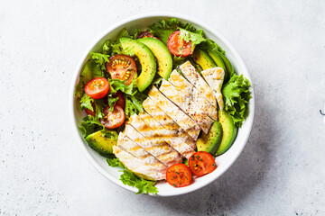 Grilled chicken breast salad with avocado and cherry tomatoes. Healthy diet food concept.