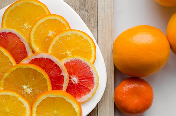 Fresh raw grapefruit and oranges (citrus x paradisi) on wooden background